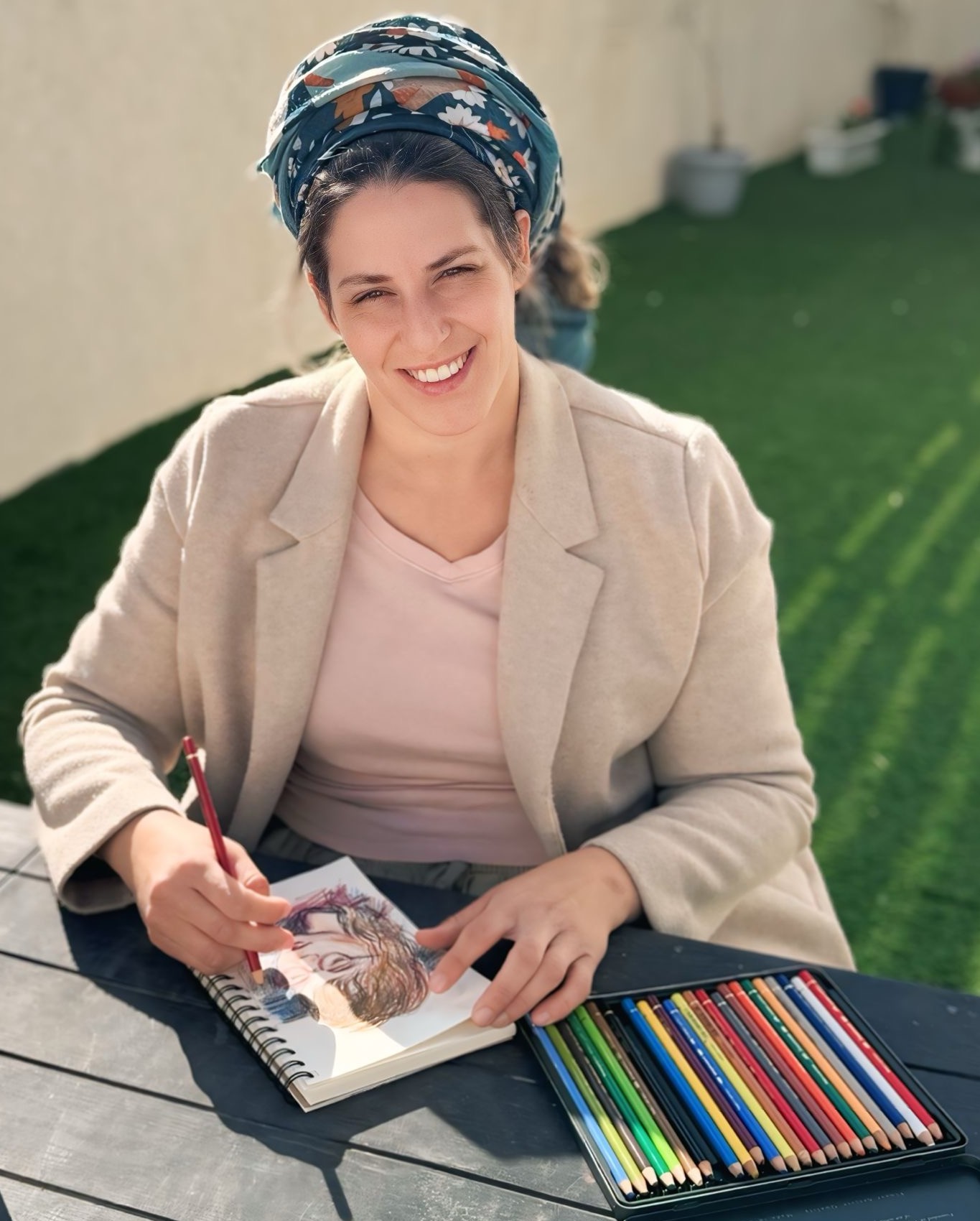 בת-שיר מציירת בחוץ עם עפרונות צבעוניים